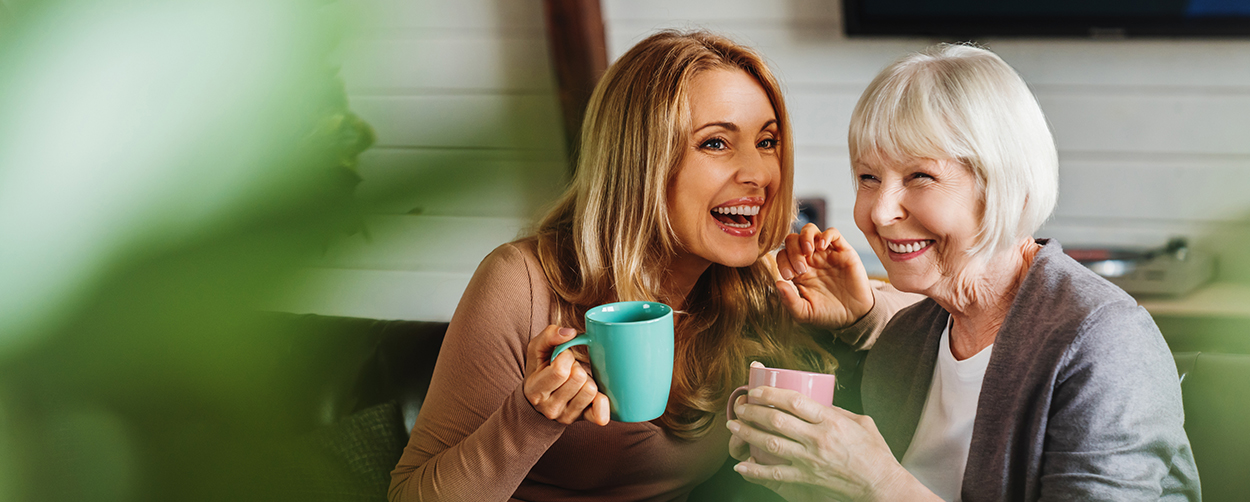Mother and Daughter laughing and enjoying coffee